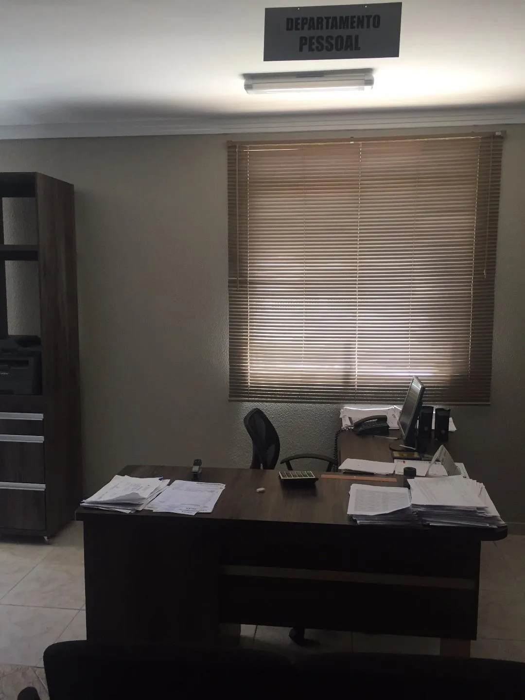 Sala do Departamento Pessoal, com mesa, computador e documentos